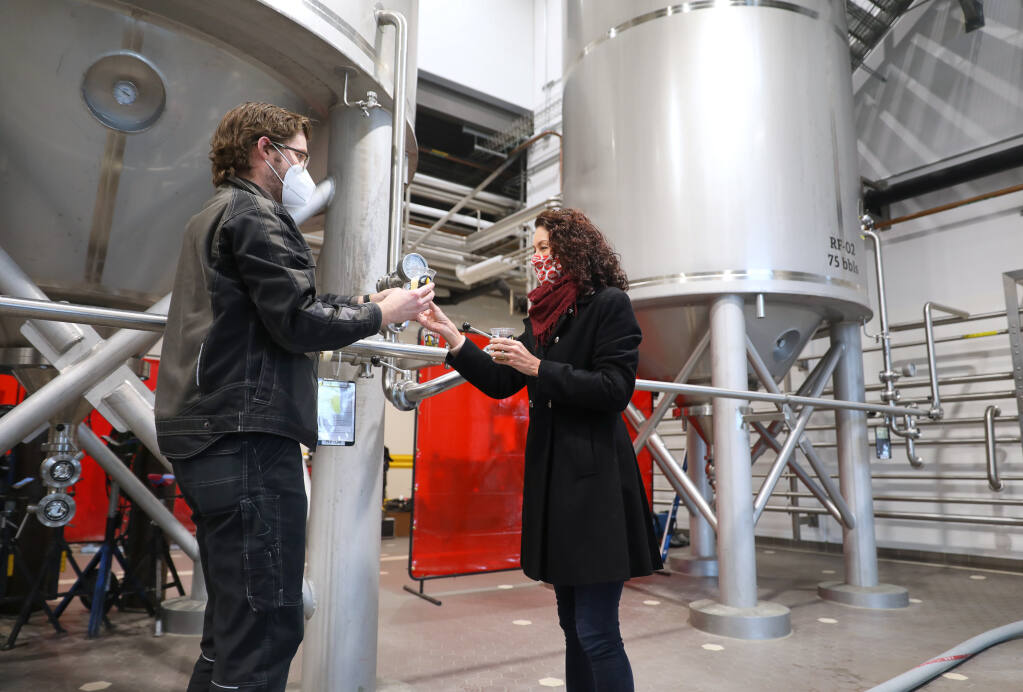 Russian River Brewing Co. production manager Stephen Rawlings, left, and co-owner Natalie Cilurzo taste a sample of Pliny the Younger from a tank at the brewery in Windsor on Tuesday, Jan. 26, 2021. (Christopher Chung / The Press Democrat)