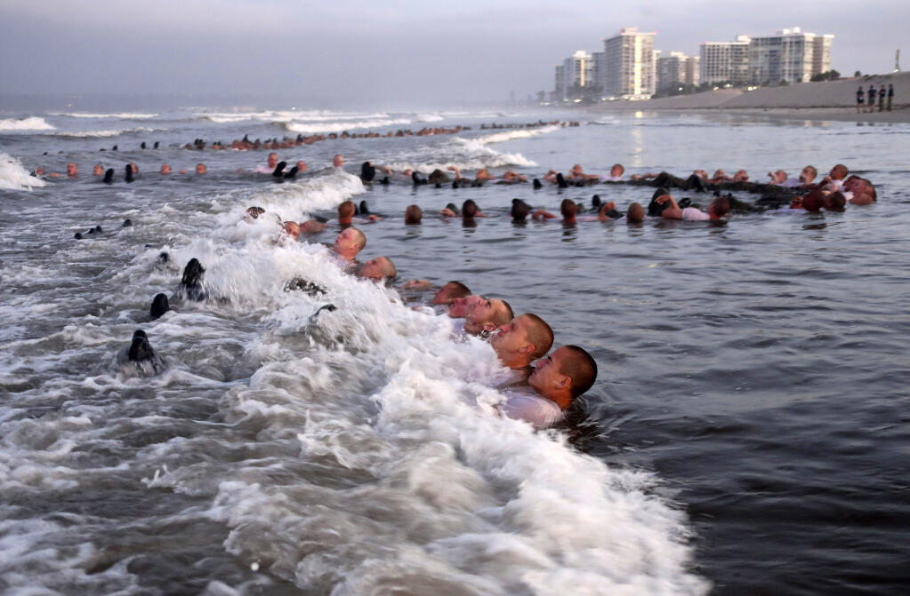 FILE - U.S. Navy SEAL candidates, participate in "surf immersion" during Basic Underwater Demolition/SEAL (BUD/S) training at the Naval Special Warfare (NSW) Center in Coronado, Calif., on May 4, 2020. (MC1 Anthony Walker/U.S. Navy via AP, File)