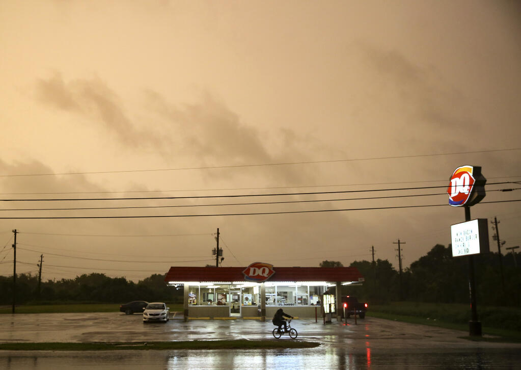 A Dairy Queen in Bay City, Texas, stays open as customers try to get in a meal before it closes as Tropical Storm Nicholas approaches on Monday, Sept. 13, 2021. (Elizabeth Conley/Houston Chronicle via AP)
