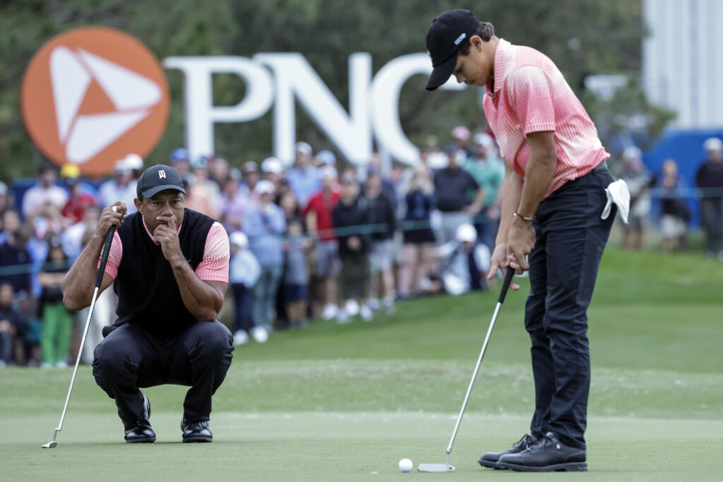 Tiger Woods, left, watches his son Charlie Woods, right, putt on the 18th green during Saturday’s first round of the PNC Championship in Orlando, Florida. (Kevin Kolczynski / ASSOCIATED PRESS)