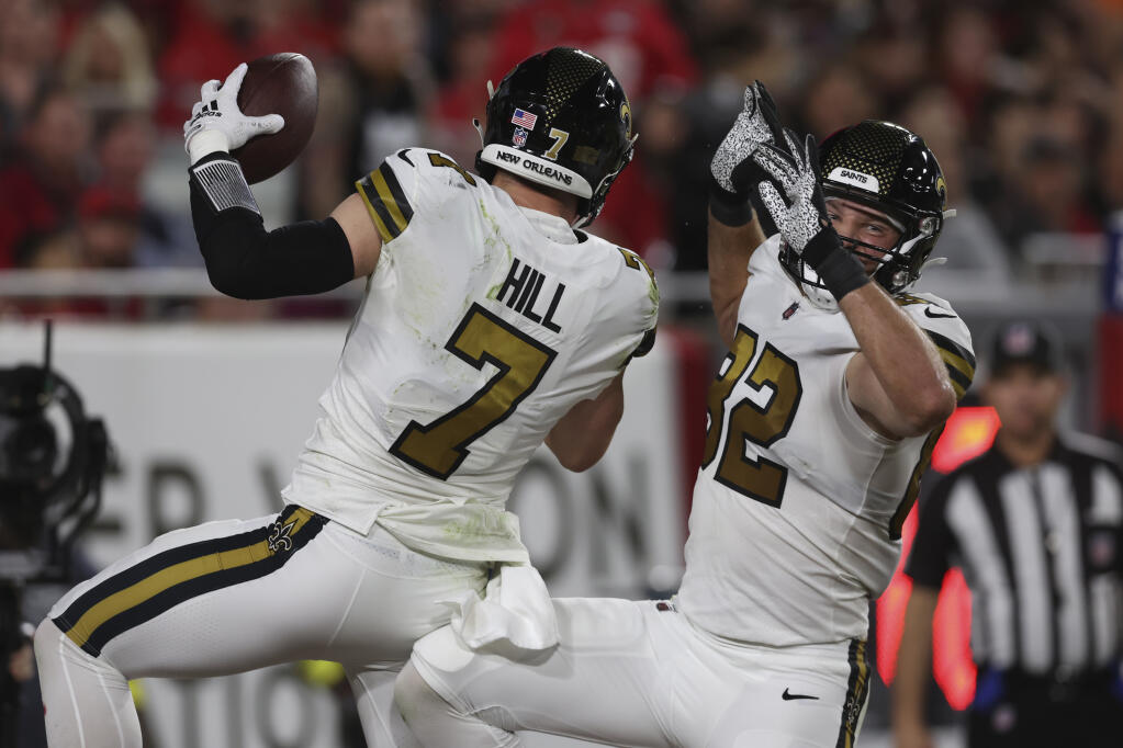 New Orleans Saints Taysom Hill (7) celebrates his touchdown reception with tight end Adam Trautman (82) in the first half of an NFL football game in Tampa, Fla., Monday, Dec. 5, 2022. (AP Photo/Mark LoMoglio)