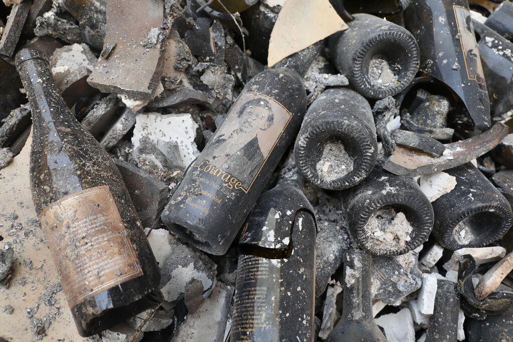 A bottle of Courage lays among the rubble of the Fairwinds Estate Winery, which was destroyed by the Glass incident fire, in St. Helena on Tuesday, September 29, 2020.  (Christopher Chung/ The Press Democrat)