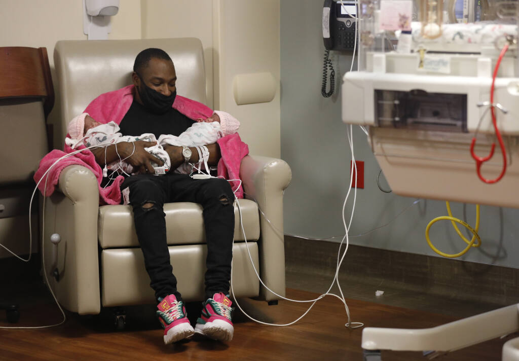 K. James holds his identical twin daughters Ke'ziah James, left, and Ke'lizah James, right, in the NICU born just a few hours earlier at Sutter Santa Rosa Regional Hospital in Santa Rosa, Calif., on Tuesday, February 22, 2022.(Beth Schlanker/The Press Democrat)