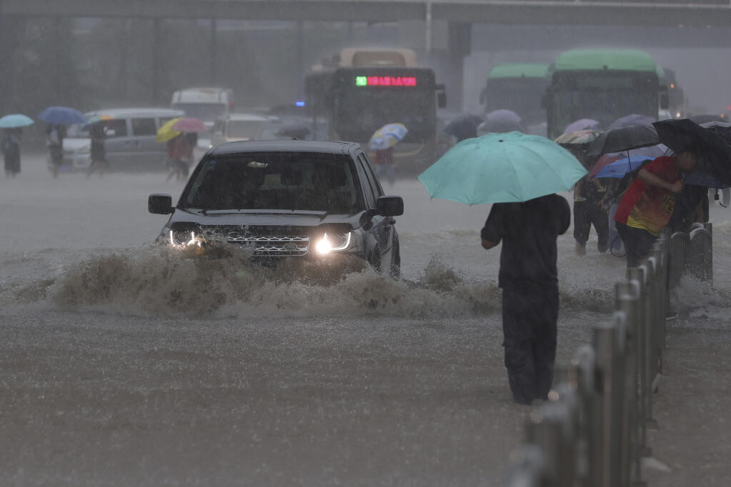 Heavy downpour in Zhengzhou city, central China's Henan province on Tuesday, July 20, 2021. Heavy flooding has hit central China following unusually heavy rains, with the subway system in the city of Zhengzhou inundated with rushing water. (Chinatopix Via AP)