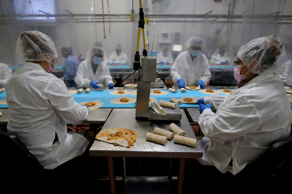 Employees roll up bean and cheese burritos in the Amy's Kitchen production facility in Santa Rosa, Calif., on Wednesday, February 16, 2022.(Beth Schlanker/The Press Democrat)