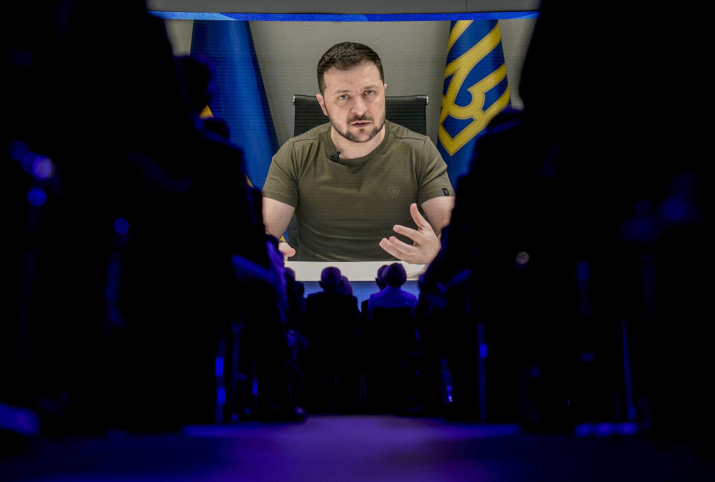 Ukrainian President Volodymyr Zelenskyy displayed on a screen as he addresses the audience from Kyiv on a screen during the World Economic Forum in Davos, Switzerland, Monday, May 23, 2022. The annual meeting of the World Economic Forum is taking place in Davos from May 22 until May 26, 2022. (AP Photo/Markus Schreiber)