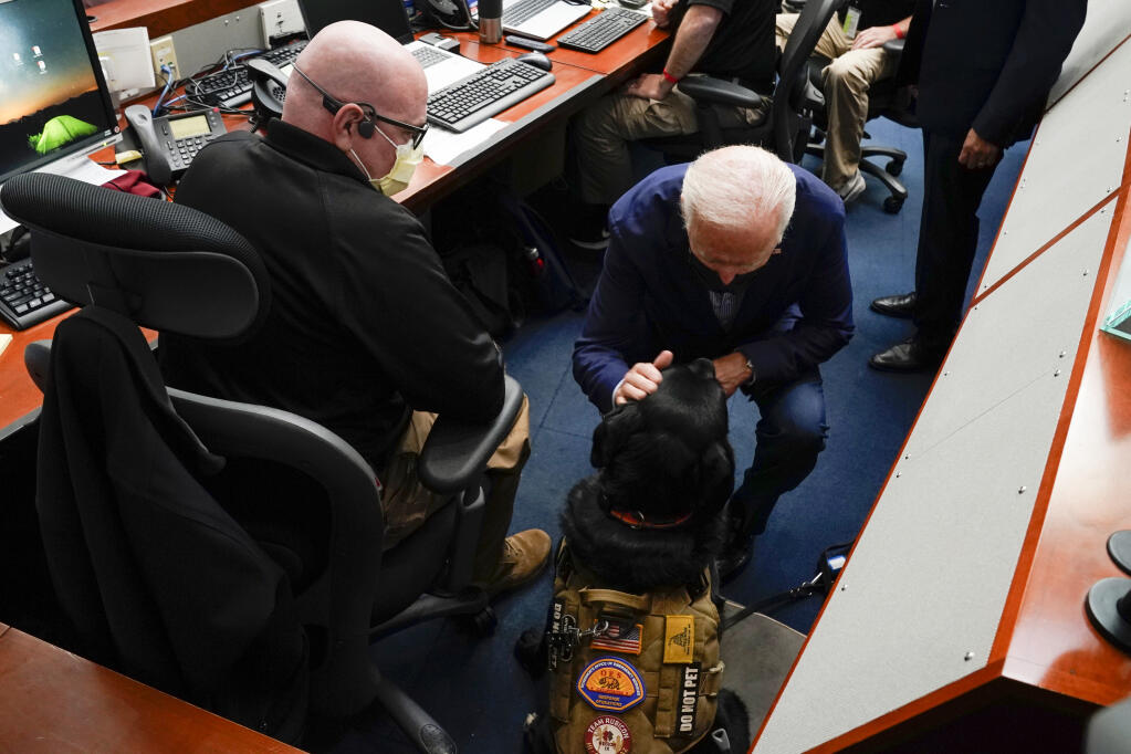 President Joe Biden pets a service dog during a briefing on wildfires at the California Governor's Office of Emergency Services, Monday, Sept. 13, 2021, in Mather, Calif. (AP Photo/Evan Vucci)