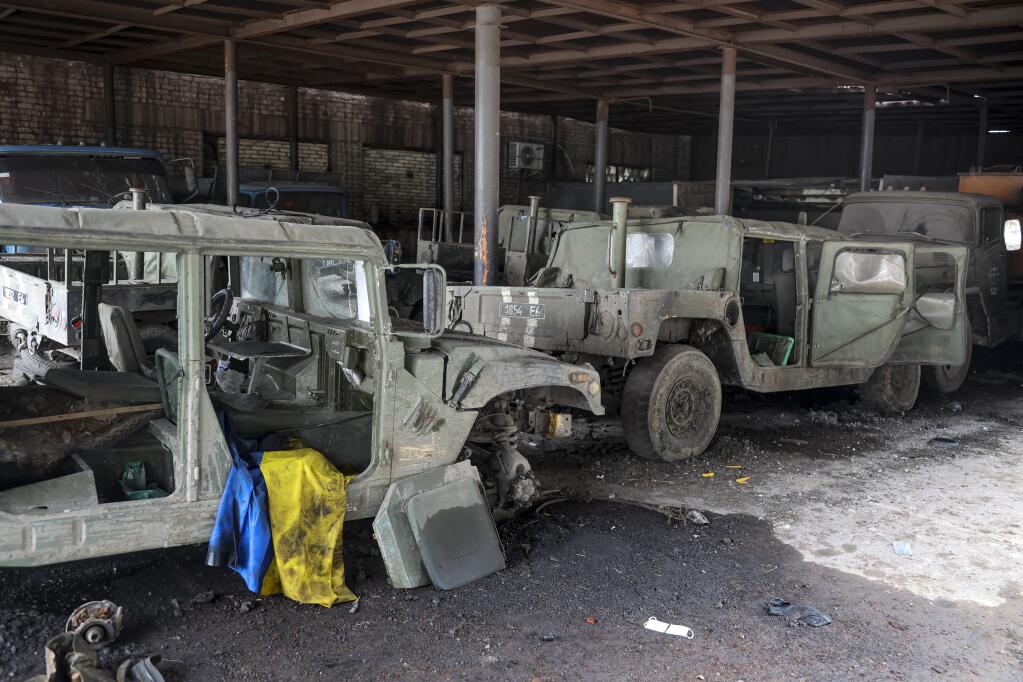 FILE - Damaged Ukrainian army military vehicles with a Ukrainian national flag, are seen at the partly destroyed Illich Iron & Steel Works Metallurgical Plant, in an area controlled by Russian-backed separatist forces in Mariupol, Ukraine, Monday, April 18, 2022. On Thursday, April 21, 2022, Russian President Vladimir Putin ordered his forces not to storm the last remaining Ukrainian stronghold in the besieged city of Mariupol but to block it “so that not even a fly comes through.” (AP Photo/Alexei Alexandrov, File)
