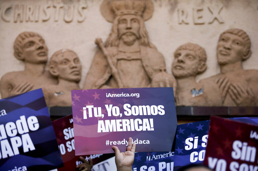 A woman holds a sign that says in Spanish, “You, me, we are America!” (GREGORY BULL / Associated Press, 2015)
