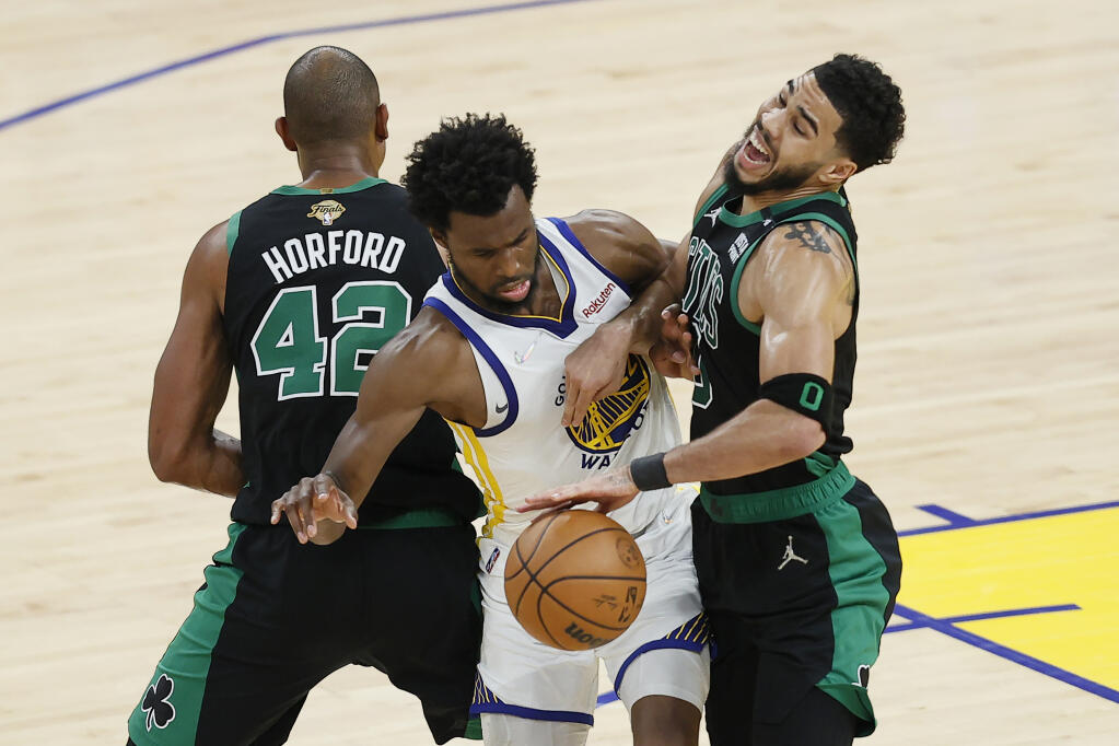 Golden State Warriors forward Andrew Wiggins, middle, goes toward the ball between Boston Celtics center Al Horford (42) and forward Jayson Tatum during the second half of Game 5 of the NBA Finals in San Francisco, Monday, June 13, 2022. (AP Photo/John Hefti)