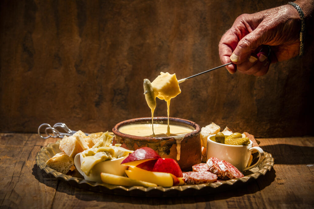 Classic Swiss Cheese Fondue from Chef John Ash can be served with bread, cornichons, apples, salami and artichokes. (John Burgess/The Press Democrat)