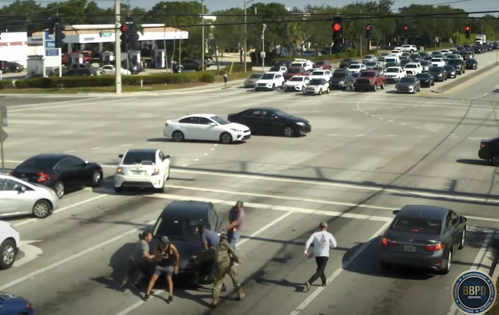 The Boynton Beach Police Department released footage of people rushing into traffic to stop a car driven by a woman who had fallen unconscious. (Boynton Beach Police Department)