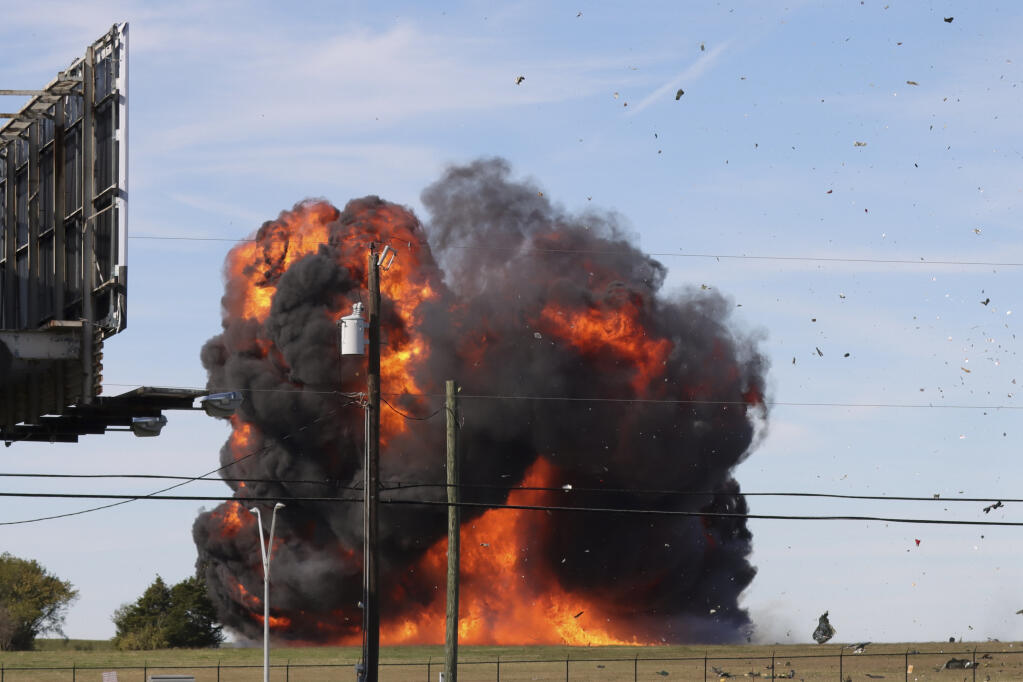 In this photo provided by Nathaniel Ross Photography, a historic military plane crashes after colliding with another plane during an airshow at Dallas Executive Airport in Dallas on Saturday, Nov. 12, 2022. (Nathaniel Ross Photography via AP)