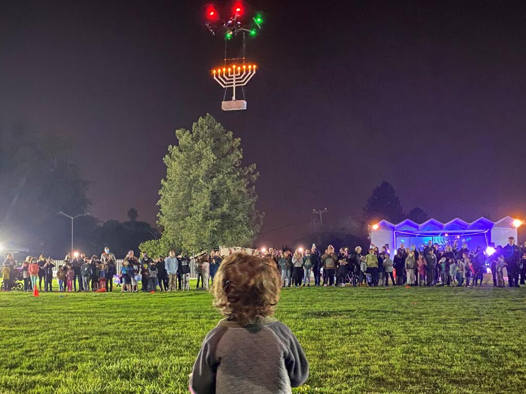 A child watches the “drone-orah” in the sky over the Petaluma fairgrounds at the 2021 Hanukkah celebration sponsored by Chabad Jewish Center of Petaluma. (Courtesy of Chabad Jewish Center)