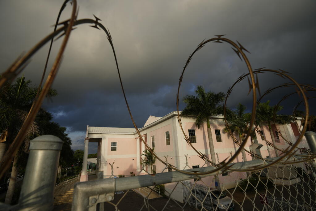 A fence topped with barbed wire surrounds the Magistrate Court building, where FTX founder Sam Bankman-Fried was expected to appear later in the morning for an extradition hearing, in Nassau, Bahamas, early on Monday, Dec. 19, 2022.(AP Photo/Rebecca Blackwell)