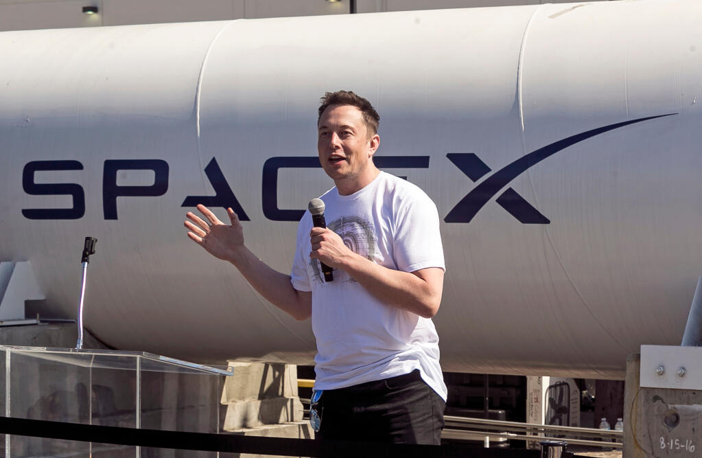 FILE - In this Aug. 27, 2017 file photo, SpaceX CEO Elon Musk congratulates teams competing on the Hyperloop Pod Competition II at SpaceX's Hyperloop track in Hawthorne, Calif. (AP Photo/Damian Dovarganes, File)