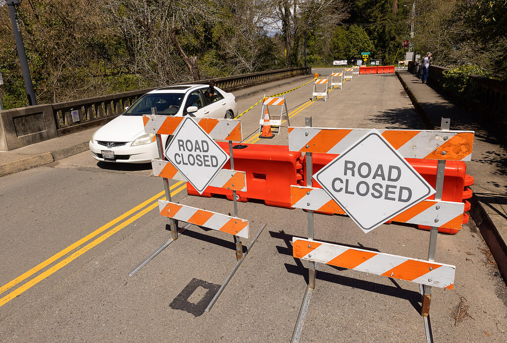 The eastbound lane of Main Street in Monte Rio is closed to traffic after concrete piles holding up the Dutch Bill creek bridge where damage by debris flowing down the creek into the Russian River, Thursday March 30, 2023.  (John Burgess / The Press Democrat)