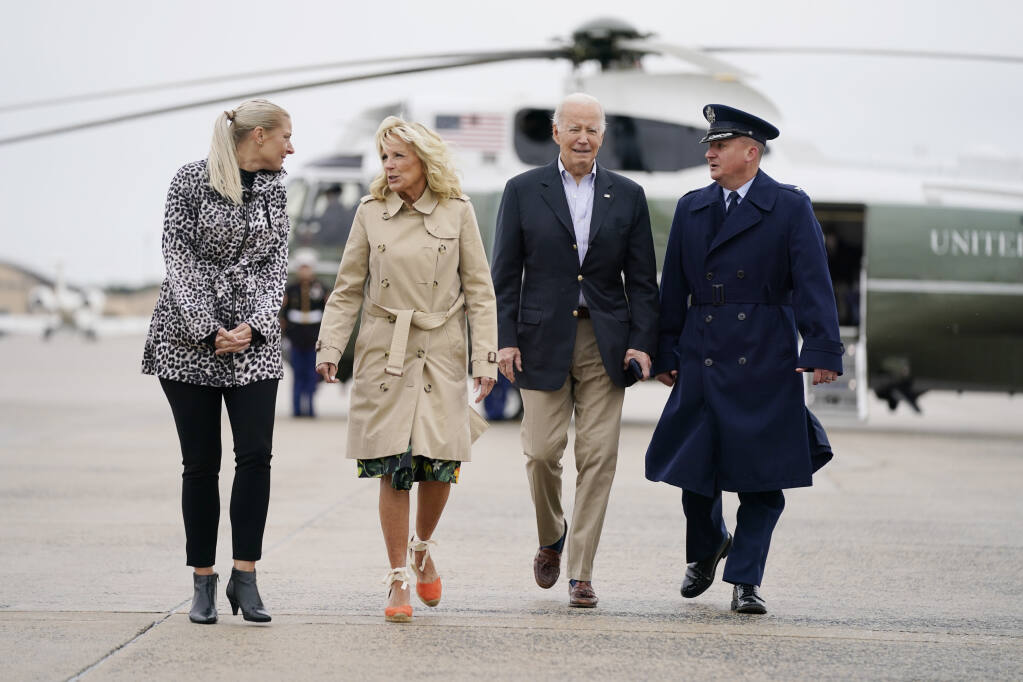 President Joe Biden and first lady Jill Biden walk to board Air Force One for a trip to Puerto Rico to survey storm damage from Hurricane Fiona, Monday, Oct. 3, 2022, at Andrews Air Force Base, Md., escorted by Col. Matthew Jones, Commander, 89th Airlift Wing and Mrs. Christie Jones, spouse of Colonel Jones. (AP Photo/Evan Vucci)