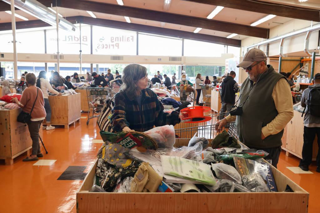Laurie and Ken McAdams look through a bin of items at Falling Prices in Santa Rosa on Thursday, April 21, 2022.  (Christopher Chung/ The Press Democrat)