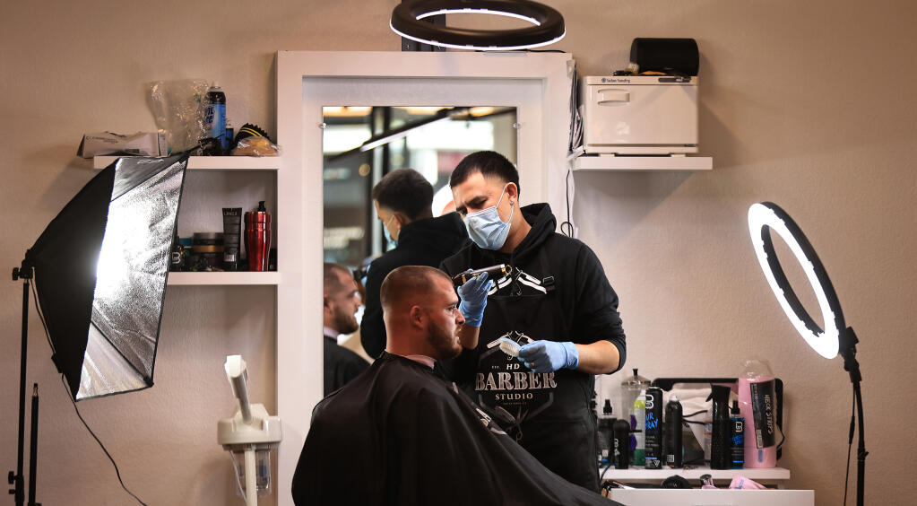 HD Barber Studio owner Erick Lopez trims up Angel Alcala, Thursday, Oct. 7, 2021 in Petaluma.  (Kent Porter / The Press Democrat) 2021