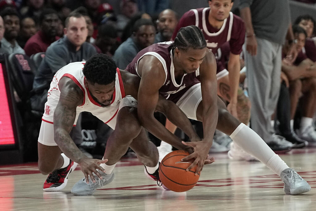 Houston's Jamal Shead, left, and Texas Southern's Davon Barnes battle for a loose ball during the second half of an NCAA college basketball game Wednesday, Nov. 16, 2022, in Houston. (AP Photo/David J. Phillip)