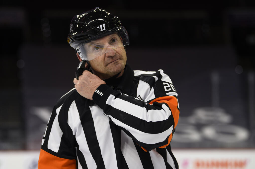 FILE - Referee Tim Peel is shown during an NHL hockey game between the Philadelphia Flyers and the New York Islanders in Philadelphia, in this Saturday, Jan. 30, 2021, file photo. Tim Peel's career as an NHL referee is over after his voice was picked up by a TV microphone saying he wanted to call a penalty against the Nashville Predators. The league on Wednesday, March 24, 2021, announced that Peel “no longer will be working NHL games now or in the future.” The 54-year-old Peel had already made plans to retire next month.(AP Photo/Derik Hamilton, File)