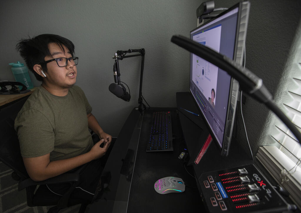 Elsie Allen High School senior Rocky Moh works on a voice over for his YouTube channel, Rocky Finance, while producing a video on Roth IRAs in his southwest Santa Rosa bedroom. April 15, 2022.  (Chad Surmick / The Press Democrat)