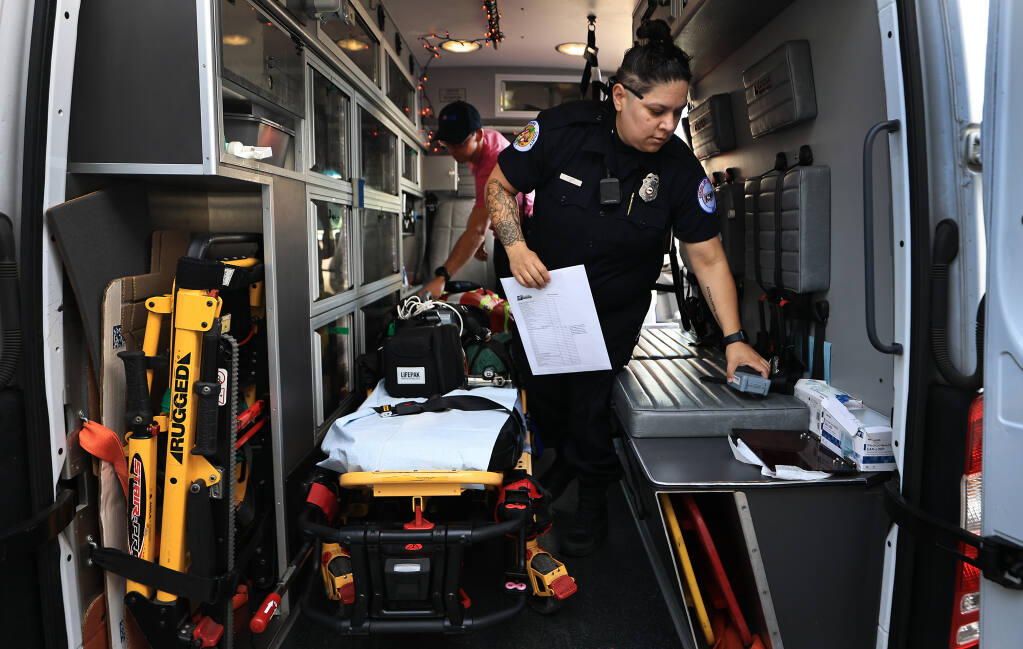 Sonoma Life Support /American Medical Response EMT Cristal Lemus, front, and Lucas Roberts do their daily checks of supplies as they come on shift, Wednesday, Oct. 26, 2022, in Santa Rosa (Kent Porter/The Press Democrat)