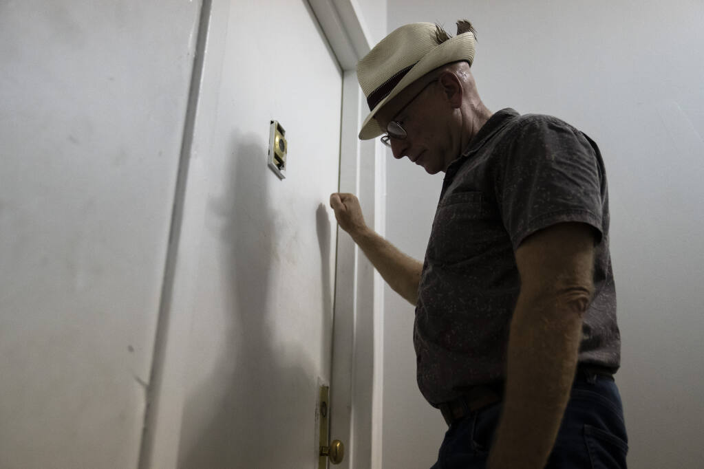 Gary Zaremba knocks on an apartment door as he checks in with tenants to discuss building maintenance at one of his at properties, Thursday, Aug. 12, 2021, in the Queens borough of New York. Landlords say they have suffered financially due to various state, local and federal moratoriums in place since last year. “Without rent, we’re out of business," said Zaremba. (AP Photo/John Minchillo)