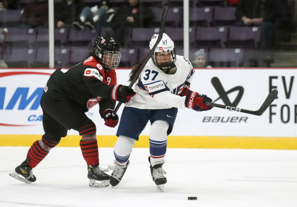 United States forward Abbey Murphy battles for the puck with Japan defender Akane Hosoyamada during the third period at the women's world hockey championship in Brampton, Ontario, Wednesday, April 5, 2023. (Nathan Denette / Canadian Press)