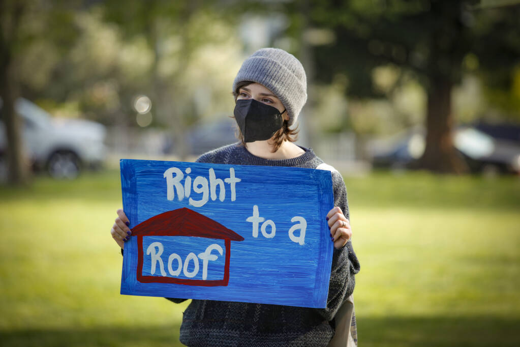 Sarah Soss of Petaluma holds a sign while listening to speakers outside of City Hall who spoke about their experiences with unfair evictions and support for more affordable housing in Petaluma. _Monday, May 02, 2022._Petaluma, CA, USA. _(CRISSY PASCUAL/ARGUS-COURIER STAFF)