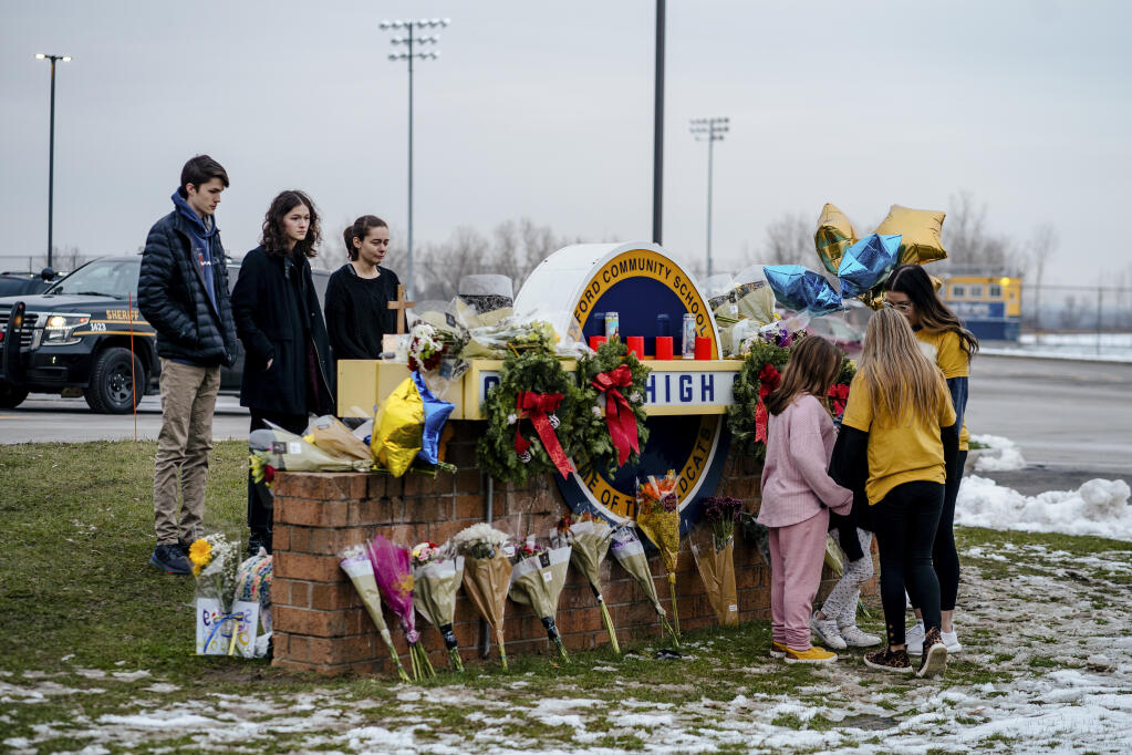 FILE — Students and mourners gathered at a makeshift memorial outside Oxford High School one day after a mass shooting at the school, in Oxford, Mich. on Dec. 1, 2021. The prosecution of James and Jennifer Crumbley could affect the courts and parenting in the wake of the worst school shooting in Michigan history. (Nick Hagen/The New York Times)