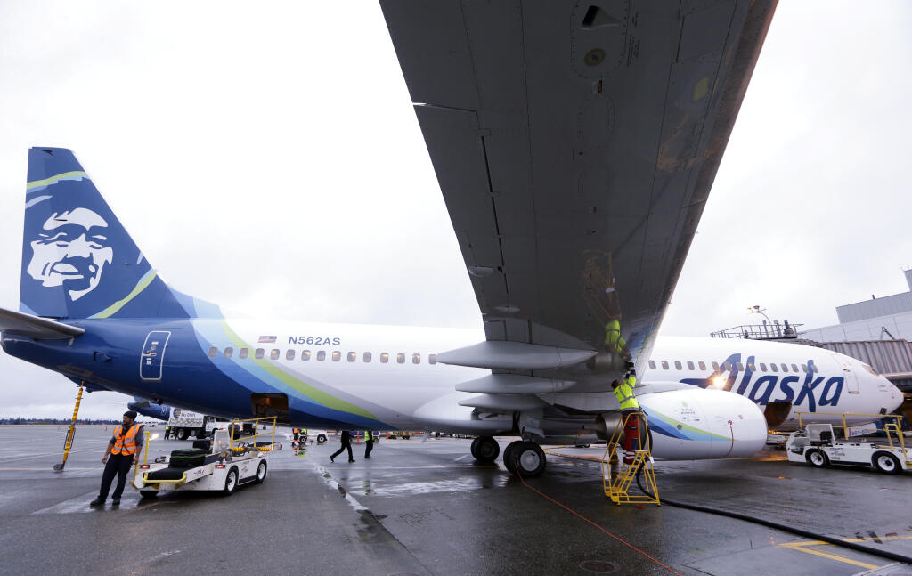 FILE — In this Nov. 14, 2016, file photo, fueling manager Jarid Svraka fuels an Alaska Airlines Boeing 737-800 jet at Seattle-Tacoma International Airport in SeaTac, Wash. (AP Photo/Elaine Thompson, File)