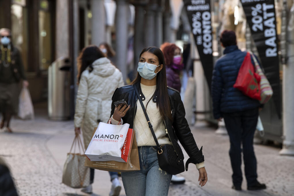 People wear face masks in Lugano, Switzerland, Tuesday, Oct. 27, 2020. (Davide Agosta/Keystone via AP)