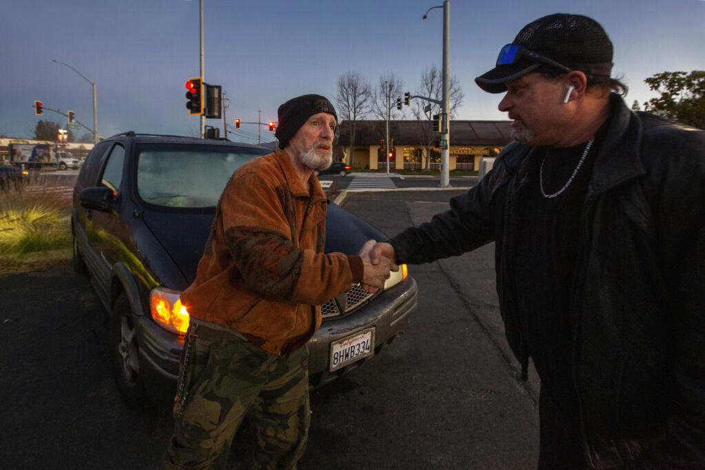 Team guide Dean Botelgio, right, gets a thankful handshake from a homeless veteran suffering from PTSD who sleeps in his car and identifies as Robert, during the Point-in-Time Homeless Count on Friday, Jan. 27, 2023. (Robbi Pengelly/Index-Tribune)