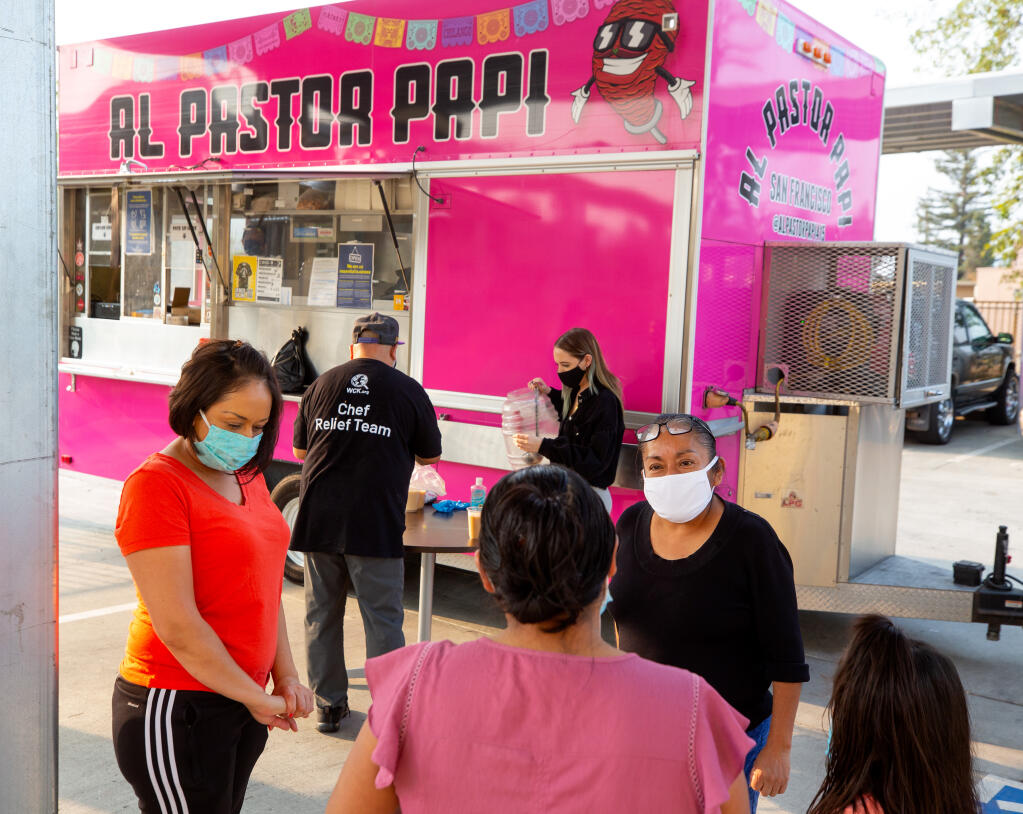 Farmworker Lidia Chavez, at right, talks with some friends in front of the Al Pastor Papi food truck in  Cloverdale on Thursday, Oct. 8, 2020. (Alvin A.H. Jornada / The Press Democrat)