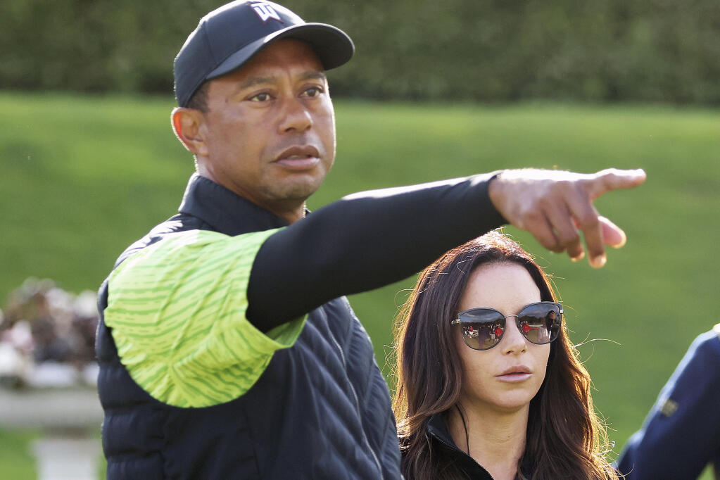 FILE - Tiger Woods and girlfriend Erica Herman on the 18th green during the JP McManus Pro-Am at Adare Manor, Limerick, Ireland, Monday, July, 4, 2022. A $30-million legal battle between Tiger Woods and his ex-girlfriend has escalated with Erica Herman accusing the golf superstar of beginning their sexual relationship when she was his employee and threatening to fire her if she didn't sign a nondisclosure agreement she now wants voided. (AP Photo/Peter Morrison, FIle)