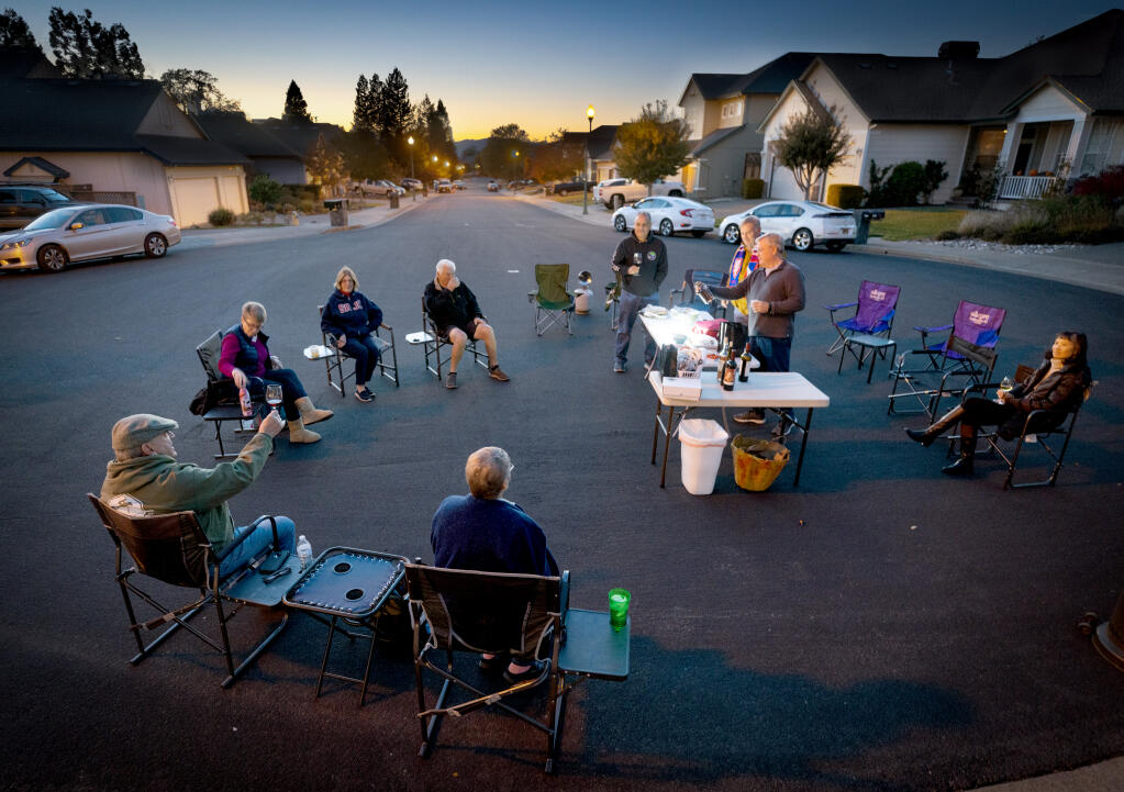 The Upper Lisa Court Friday night distanced gathering of friends met for the last night of the year on their cul-de-sac in Windsor Friday, November 18, 2022.  The group of neighbors started their parties during COVID and have become close friends since. (John Burgess/Press Democrat)