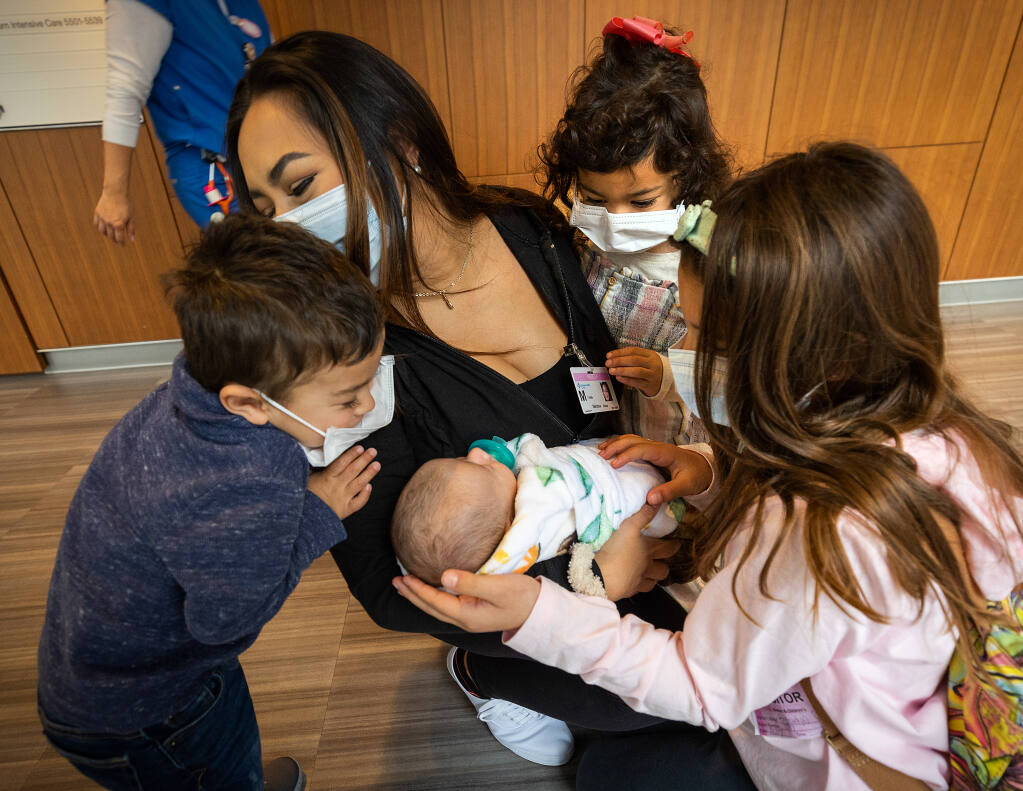 After sprinting down the hallway, siblings, from left, Lucca, 3, Vianna, 4, and Brooklyn, 8, see their brother Leo in mother Melissa Rossi’s arms for the first time since his birth on Jan. 1 while visiting at Sutter Health’s CPMC San Francisco Saturday, Feb. 4, 2023. Leo needed corrective surgery for a blocked intestine on his second day of his life. (John Burgess/The Press Democrat)