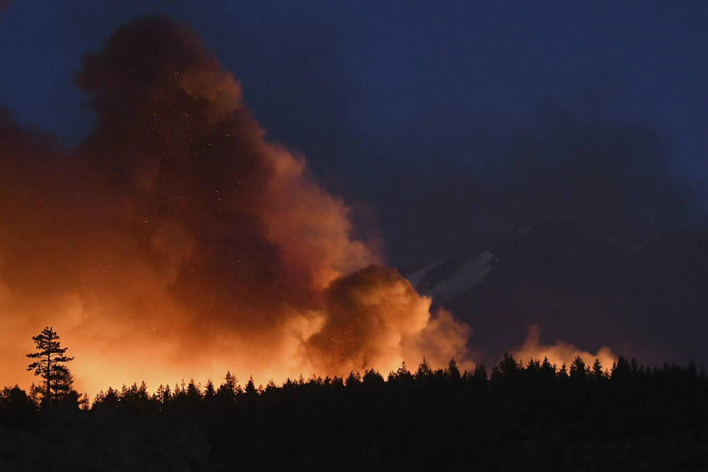 In this Monday, June 28, 2021, photo firefighters with the California Department of Forestry and Fire Protection work to extinguish hot spots after the Lava Fire burned through an area alongside U.S. Highway 97 northeast of Weed, Calif. (Scott Stoddard/Grants Pass Daily Courier via AP)