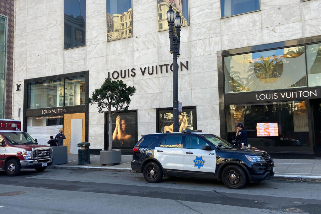 FILE - Police officers and emergency crews park outside the Louis Vuitton store in San Francisco's Union Square on Nov. 21, 2021, after looters ransacked businesses. Groups of thieves, some carrying crowbars and hammers, smashed glass cases and window displays, ransacking high-end stores throughout the San Francisco Bay Area, stealing jewelry, sunglasses, suitcases and other merchandise before fleeing in waiting cars during a weekend of brazen organized theft that shocked holiday shoppers and prompted concerns about the busy retail season. (Danielle Echeverria/San Francisco Chronicle via AP, File)