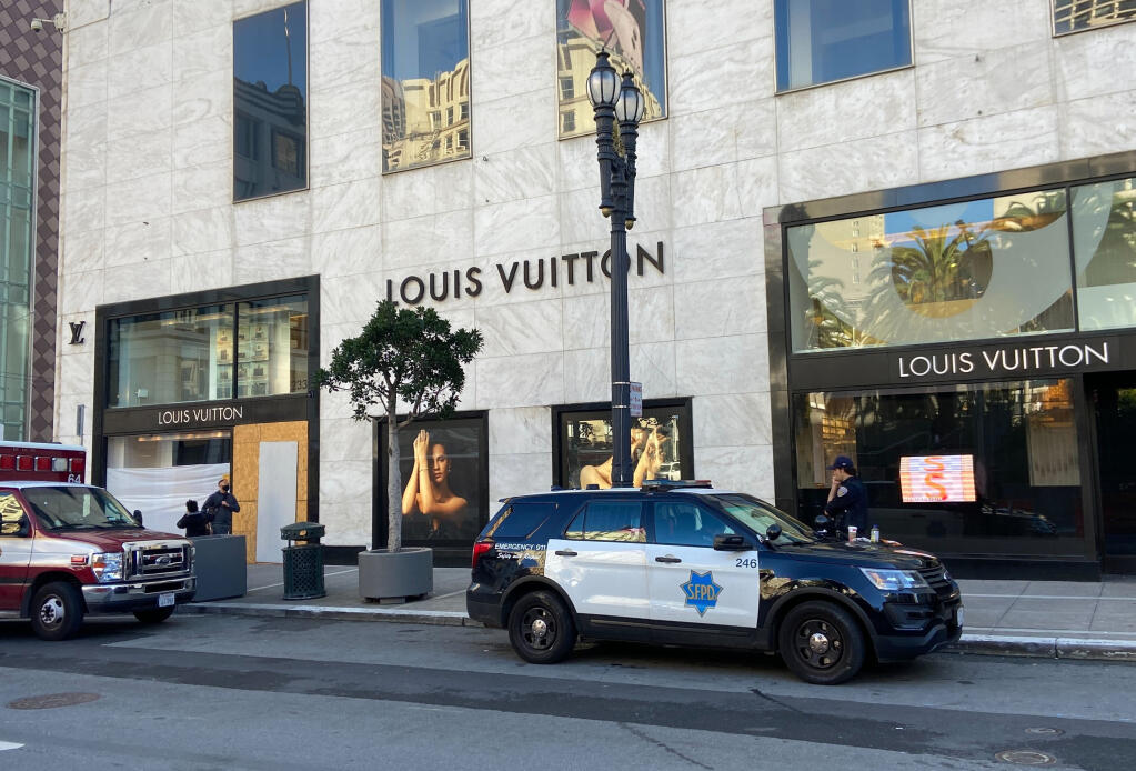 Police officers and emergency crews park outside the Louis Vuitton store in San Francisco's Union Square on Sunday, Nov. 21, 2021, after looters ransacked businesses late Saturday night. (Danielle Echeverria/San Francisco Chronicle via AP)