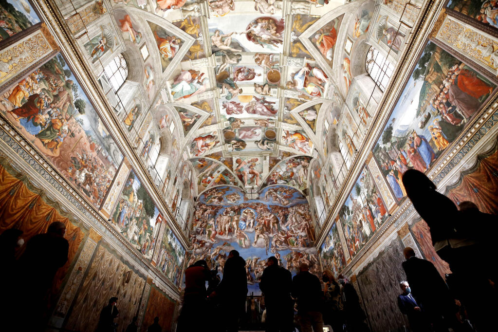 Visitors admire the Sistine Chapel of the Vatican Museums on the occasion of the museum's reopening, in Rome, Monday, May 3, 2021. The Vatican Museums reopened Monday to visitors after a shutdown following COVID-19 containment measures. (AP Photo/Alessandra Tarantino)