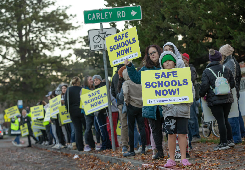 Finn Ritts, right, protests alongside parents, students and faculty during an action Friday morning outside Herbert Slater Middle School concerned about the ongoing problems of fights and weapons on campuses after recent arrests and lockdowns at the Santa Rosa school Friday Dec. 8, 2023. (Chad Surmick / The Press Democrat)