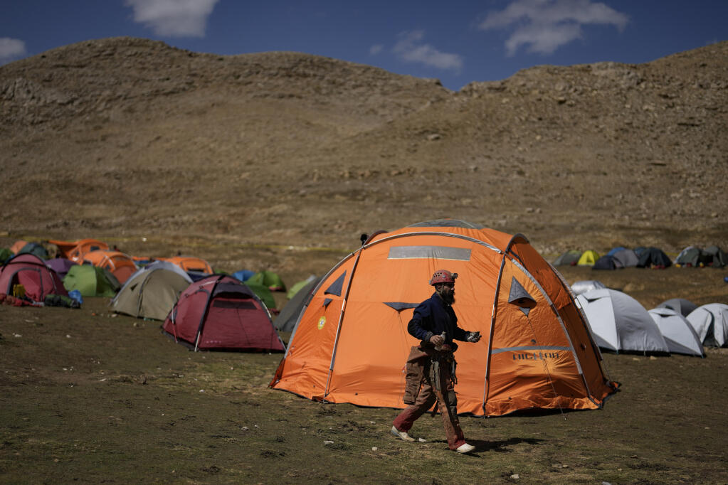 A European Cave Rescue Association (ECRA) member walks next to the tents camp during a rescue operation in the Morca cave near Anamur, south Turkey, Friday, Sept. 8, 2023. American researcher Mark Dickey, 40, who fell ill almost 1,000 meters (more than 3,000 feet) below the entrance of a cave in Turkey, has recovered sufficiently enough to be extracted in an operation that could last three or four days, a Turkish official was quoted as saying on Friday. (AP Photo/Khalil Hamra)