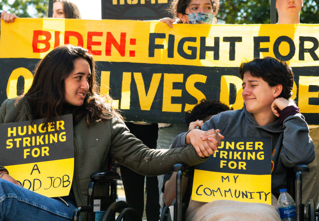 Santa Rosa 18-year-old Ema Govea, left, offers support to another member of a hunger strike for climate solutions and jobs at the White House on Friday, October 22, 2021. (Photo by Allison Bailey/NurPhoto via AP)