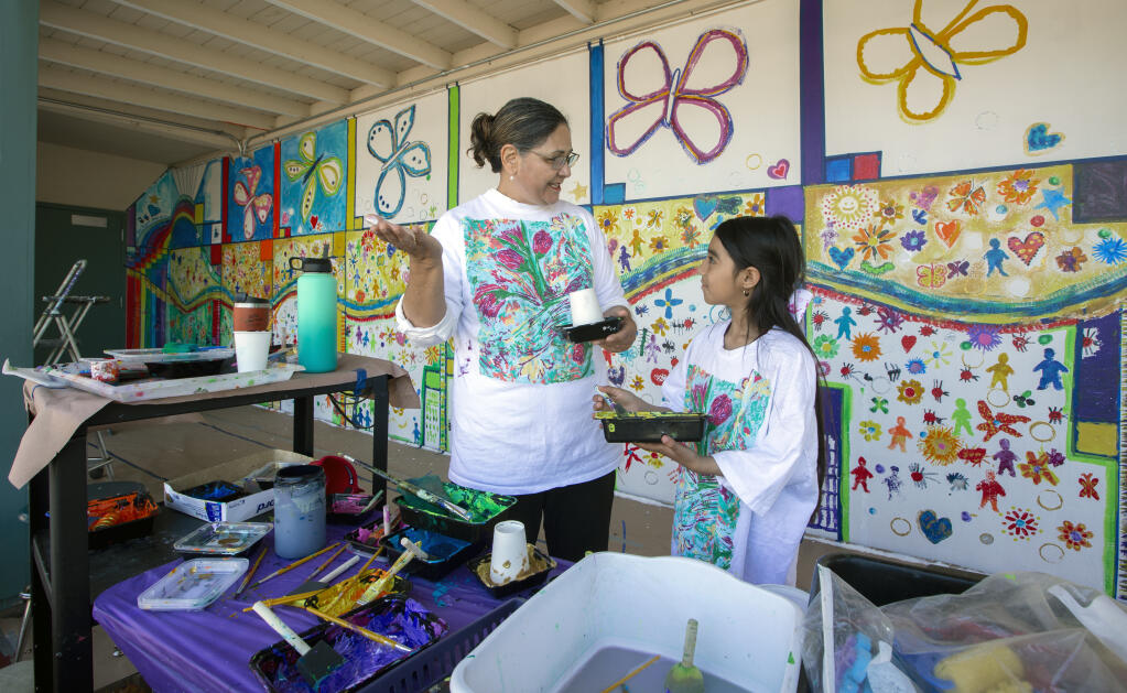 Susy Martes, SVMA mentor, chats with her mentee, first-grader Jocelin Tapia Gomez, 8, as they mix their paint for the next section of the mural at Dunbar Elementary School in Glen Ellen on Thursday, May 5, 2022. (Robbi Pengelly/Index-Tribune)
