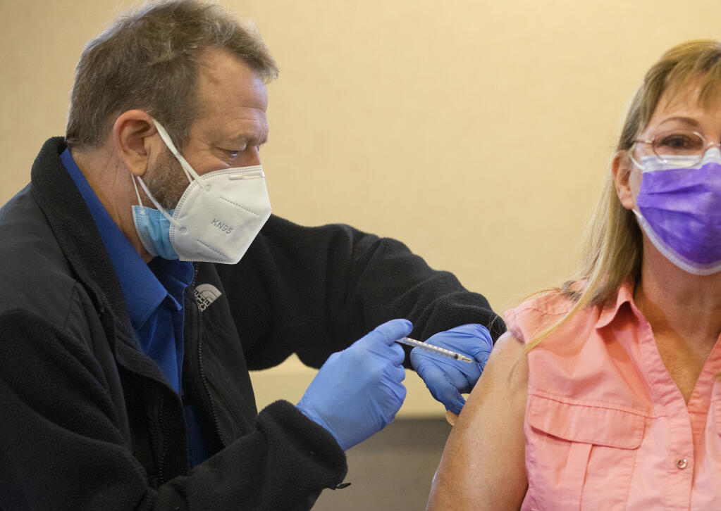 Dr. Steve Mertens injects dental office worker Jan Schwartz with her second dose of the Pfizer COVID-19 vaccine at the Sonoma County Public Health lab on Friday, Jan. 29, 2021.  (John Burgess/The Press Democrat)