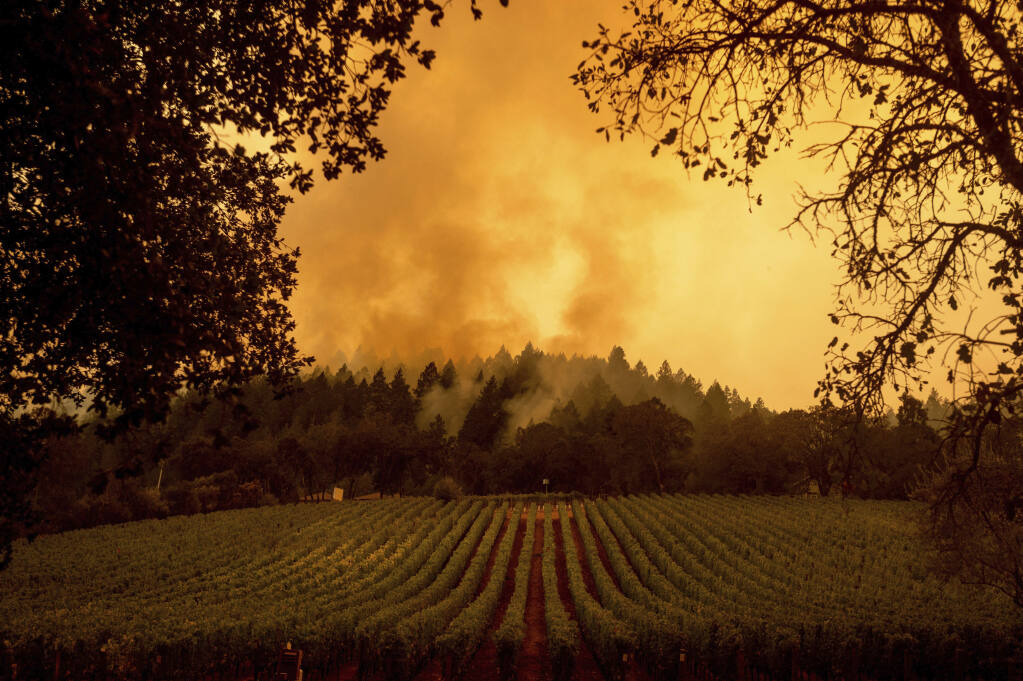 Smoke rises over a vineyard as the Glass Fire burns on Monday, Sept. 28, 2020, in Calistoga. (AP Photo/Noah Berger)