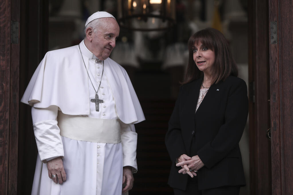 Pope Francis is greeted by Greek President Katerina Sakellaropoulou as he arrives at the Presidential Palace, in Athens, Saturday, Dec. 4, 2021. Pope Francis arrived to Greece Saturday for the second leg of his trip to the region with meetings in Athens aimed at bolstering recently-mended ties between the Vatican and Orthodox churches. (George Vitsaras/Pool Photo via AP)